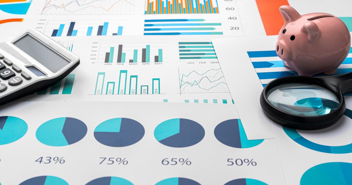 Business graphs and magnifying glass on table, close up | Metrics To Consider When Evaluating The Success Of An SEO Campaign